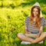 a woman sitting on grass looking at a tablet, weed allergy